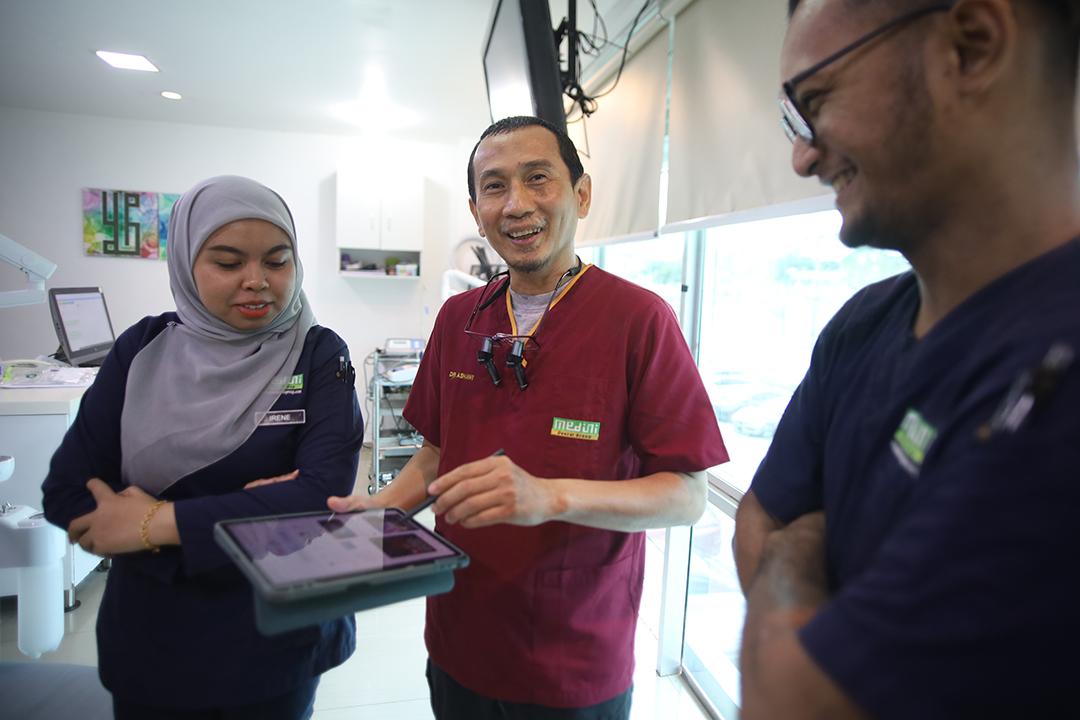 Dr. Ashawi berbincang dengan pasukan menggunakan tablet di klinik